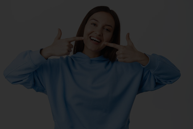 happy-girl-pointing-fingers-white-perfect-smile-straight-whitened-teeth-standing-hoodie-against-white-background_176420-47818.png